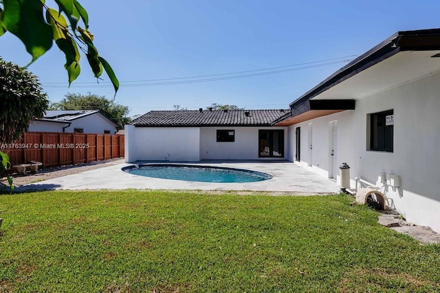 view of swimming pool with a yard, a patio area, a fenced in pool, and fence