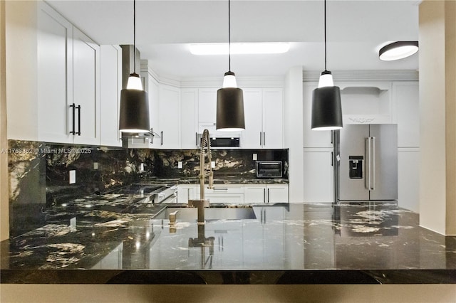 kitchen featuring dark stone countertops, high quality fridge, decorative backsplash, and decorative light fixtures