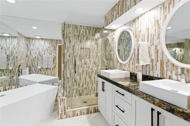 full bathroom featuring recessed lighting, tile walls, a sink, and a shower stall