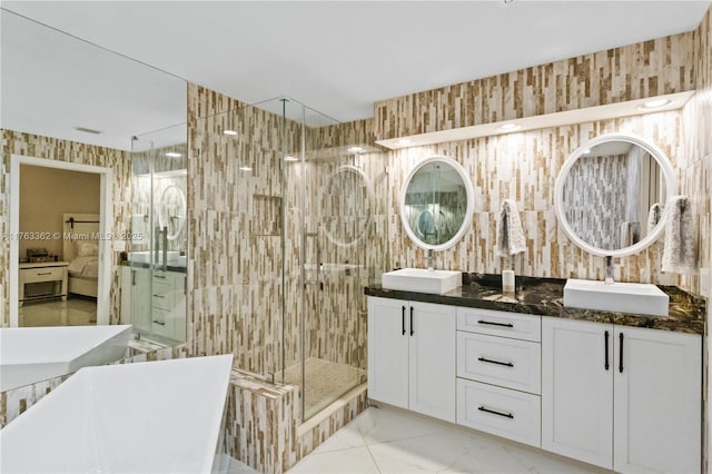 full bath featuring marble finish floor, a stall shower, a freestanding tub, and a sink