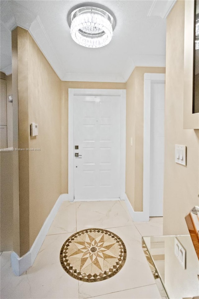 interior space with ornamental molding, marble finish floor, and baseboards