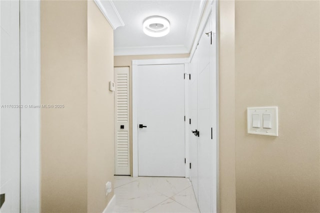 corridor featuring ornamental molding, marble finish floor, and baseboards