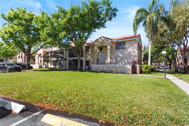 mediterranean / spanish home with a front yard, uncovered parking, and stucco siding