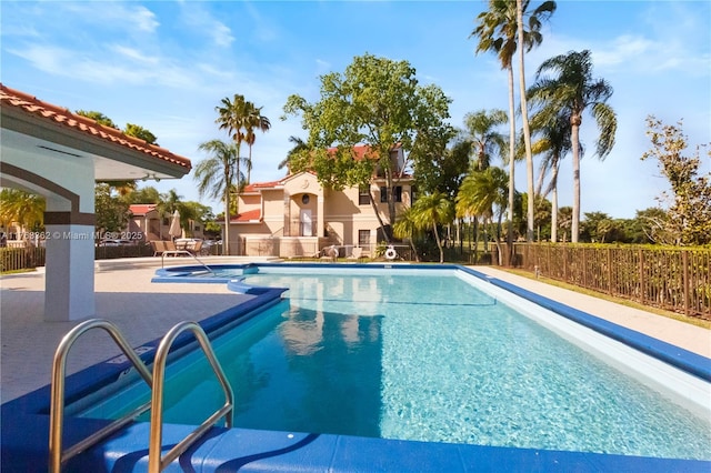 community pool featuring fence and a patio area