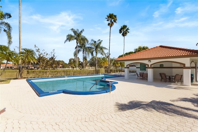 community pool featuring a patio and fence