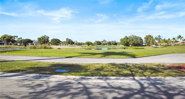 view of property's community featuring a yard and a water view