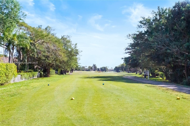 view of home's community featuring golf course view and a yard