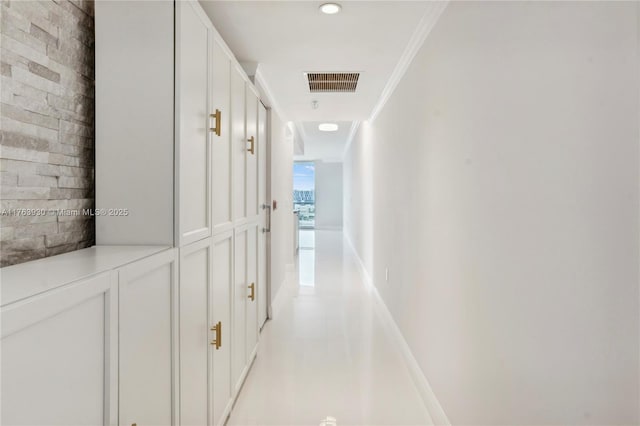 corridor featuring baseboards, visible vents, and ornamental molding