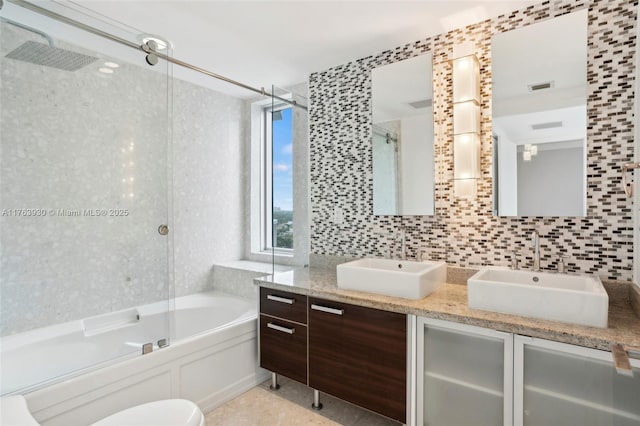 bathroom featuring double vanity, a tub to relax in, a shower with door, and a sink