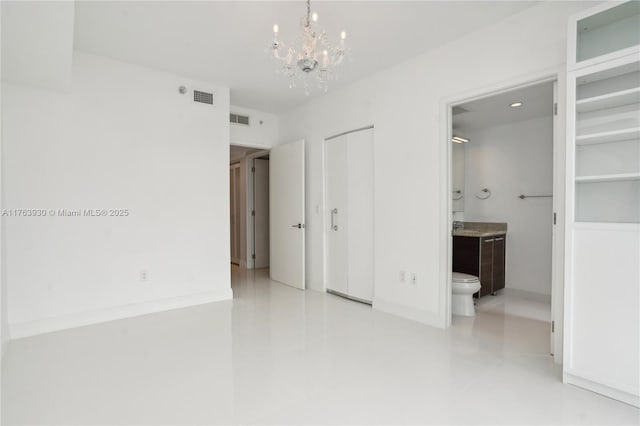 unfurnished bedroom featuring visible vents, ensuite bath, and an inviting chandelier