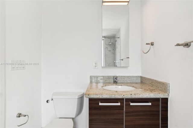 bathroom featuring a shower, toilet, and vanity