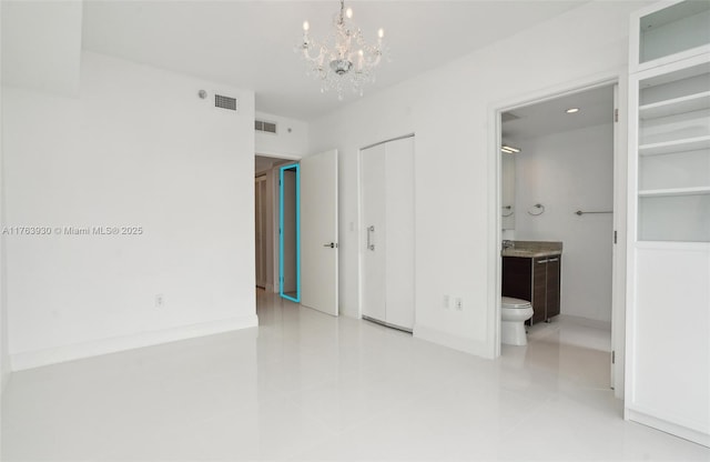 unfurnished bedroom with tile patterned floors, visible vents, an inviting chandelier, and ensuite bath