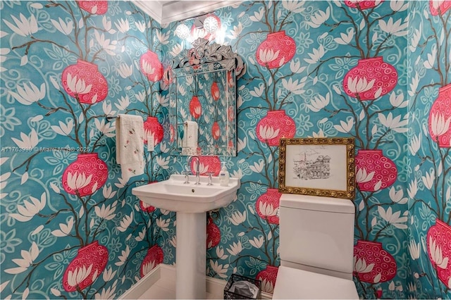 bathroom featuring wallpapered walls and toilet