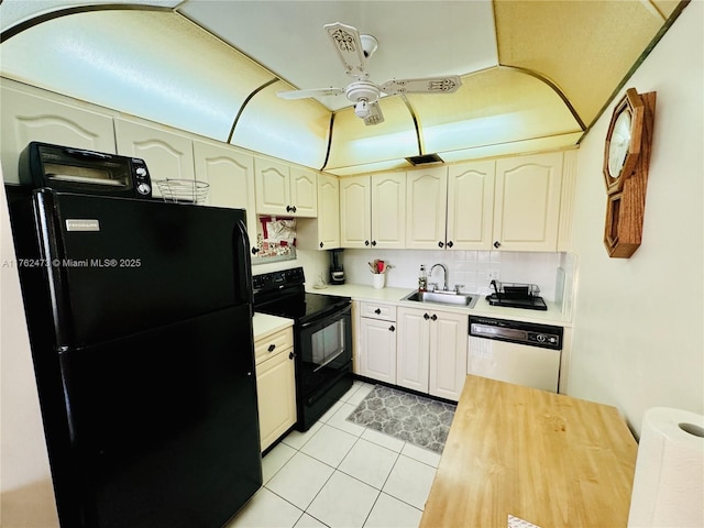 kitchen featuring black appliances, a sink, light countertops, light tile patterned floors, and ceiling fan