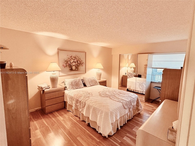 bedroom featuring wood finished floors, baseboards, and a textured ceiling