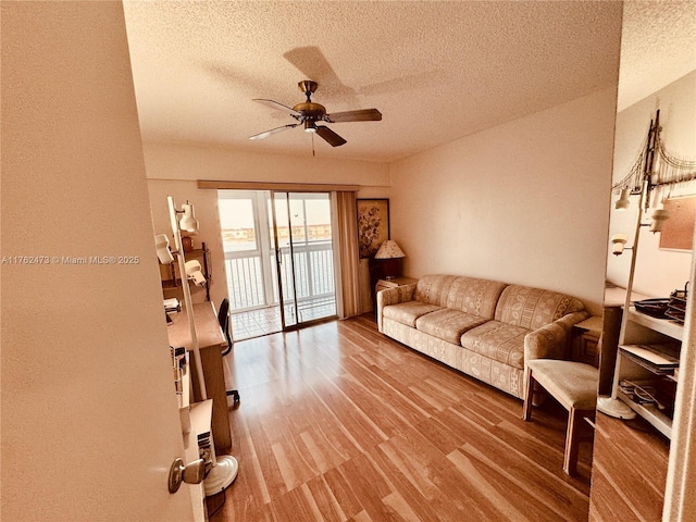 living room featuring a textured ceiling, a ceiling fan, and wood finished floors