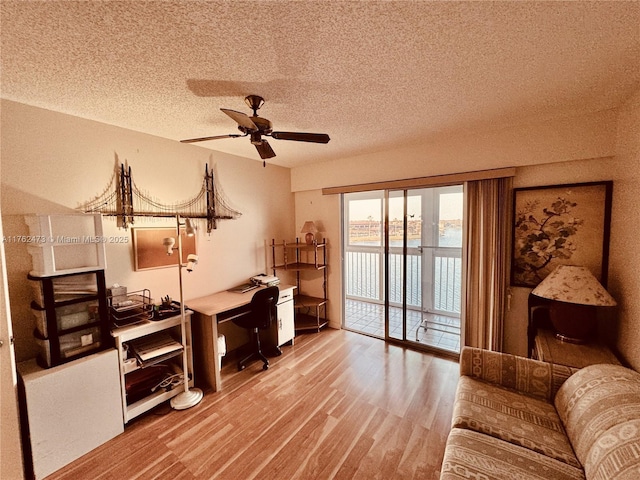 office space with a textured ceiling, a ceiling fan, and wood finished floors