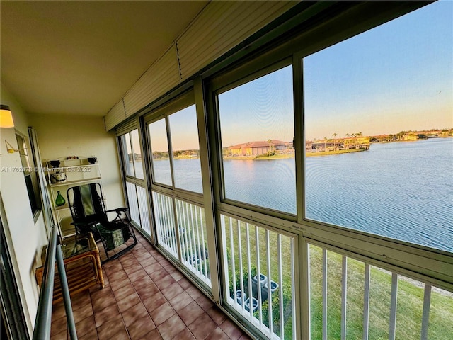 sunroom featuring a water view