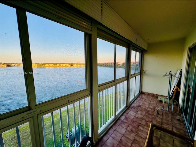 unfurnished sunroom featuring a water view