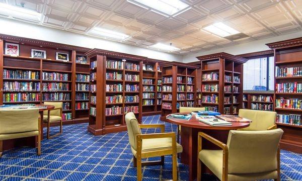 sitting room with an ornate ceiling and wall of books