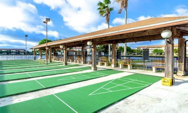 view of home's community with shuffleboard and fence