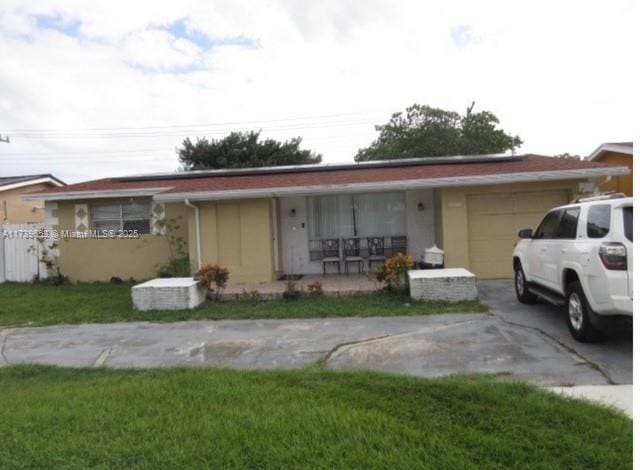 ranch-style home with a porch, stucco siding, an attached garage, and concrete driveway