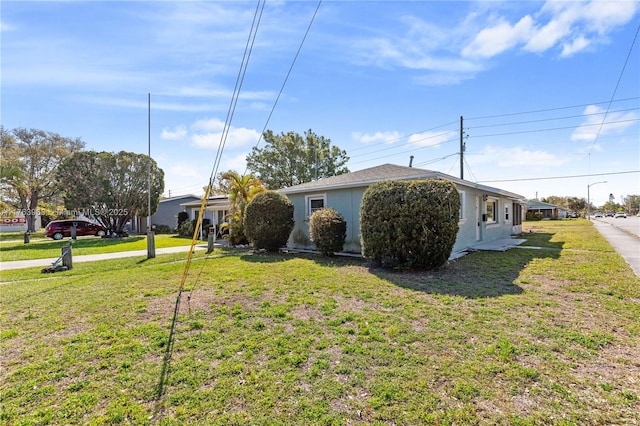 view of property exterior with stucco siding and a lawn