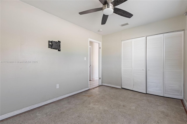 unfurnished bedroom featuring visible vents, a closet, speckled floor, baseboards, and ceiling fan