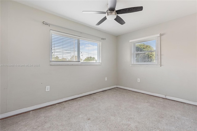 unfurnished room featuring baseboards, speckled floor, and a ceiling fan