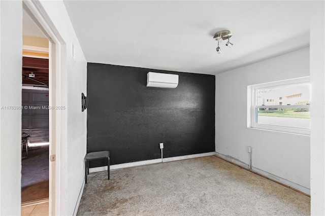 empty room featuring baseboards and a wall unit AC