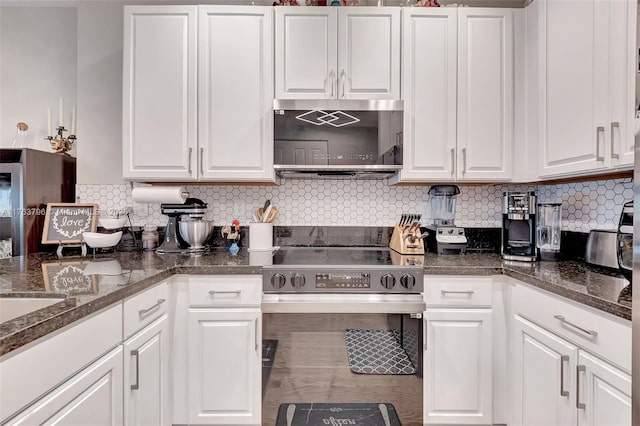 kitchen with dark stone counters, tasteful backsplash, and white cabinets