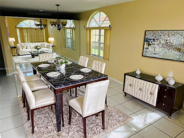 dining room featuring an inviting chandelier, light tile patterned flooring, and baseboards