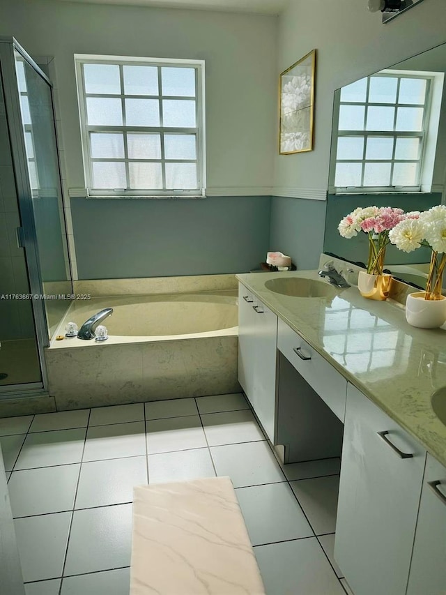 full bath with tile patterned floors, double vanity, a shower stall, and a sink