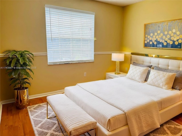 bedroom with baseboards and wood finished floors