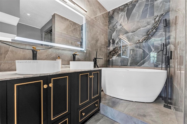 full bathroom with tile walls, double vanity, and a sink