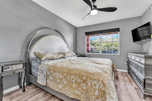 bedroom with baseboards, a textured ceiling, wood finished floors, and a ceiling fan