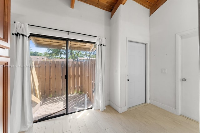 doorway featuring baseboards, beam ceiling, wood finished floors, and wooden ceiling