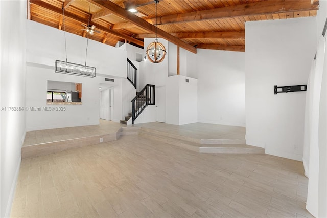 unfurnished living room featuring stairway, wood finished floors, visible vents, beam ceiling, and wood ceiling