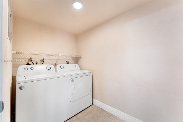 washroom featuring baseboards, independent washer and dryer, and laundry area