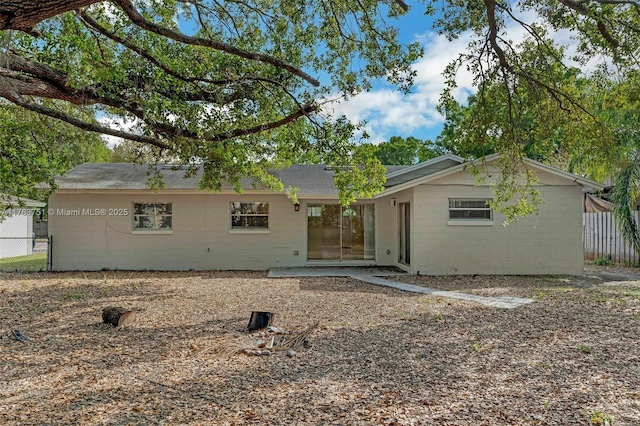 view of front of home featuring concrete block siding and fence