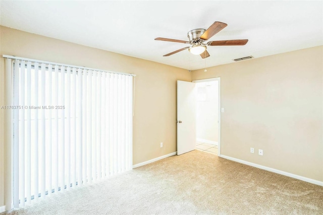 empty room with visible vents, baseboards, a ceiling fan, and carpet floors