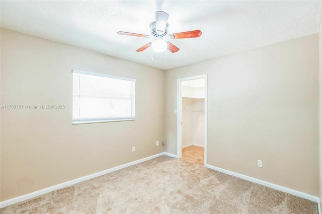 unfurnished room featuring carpet flooring, a ceiling fan, and baseboards