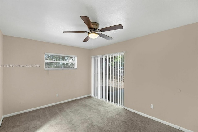 carpeted empty room featuring baseboards and ceiling fan