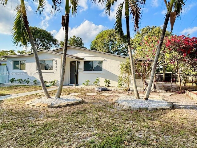 view of front facade with stucco siding and a front lawn