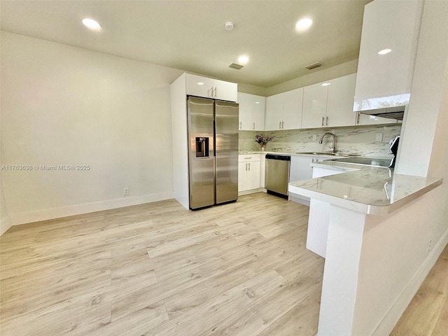 kitchen with a sink, stainless steel appliances, visible vents, and white cabinetry