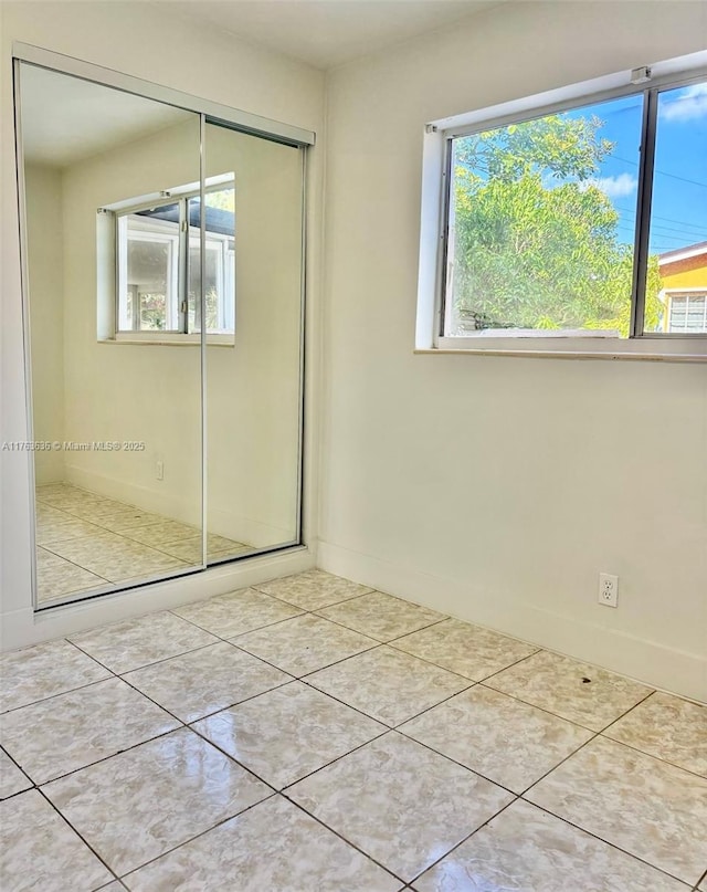 unfurnished bedroom featuring tile patterned floors and a closet