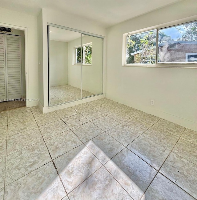 unfurnished bedroom with a closet and tile patterned flooring