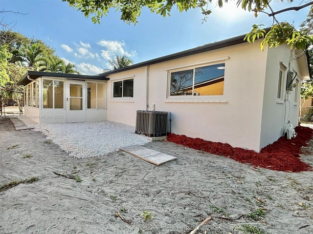 back of house featuring a patio, central air condition unit, and stucco siding