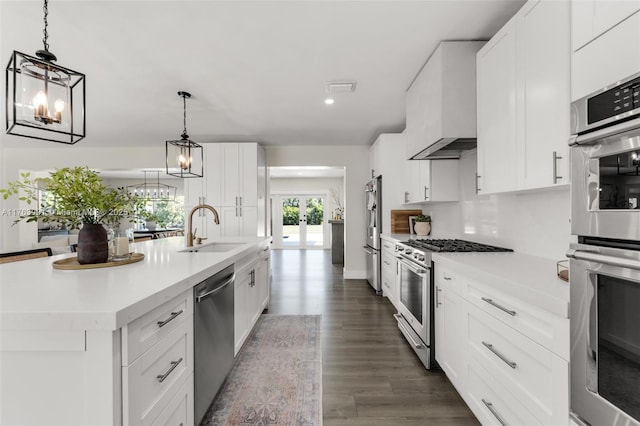 kitchen with custom exhaust hood, a chandelier, stainless steel appliances, and a sink