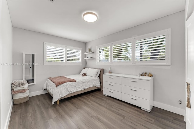 bedroom with baseboards and wood finished floors